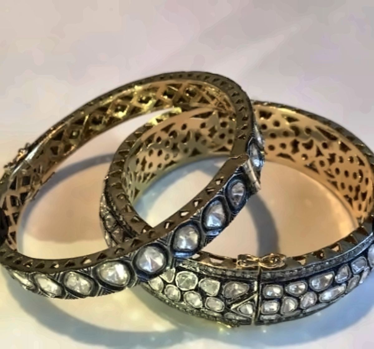 A pair of polki bangles with uncut diamonds over foil